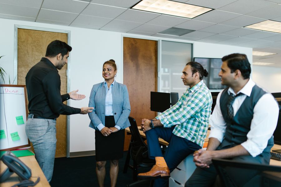 Indian professionals working a problem at a whiteboard